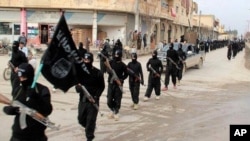Pasukan dari Negara Islam Irak dan Levant (ISIL) yang terkait al-Qaida, berbaris di Raqqa, Suriah, Januari 2014.