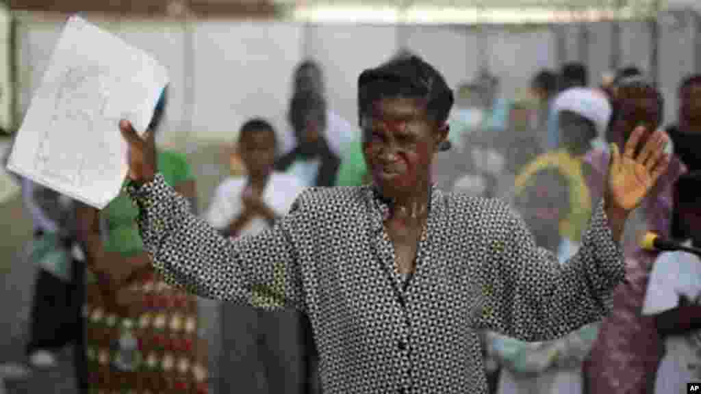 Cette femme, déclarée guérie d’Ebola, rend grâce à Dieu après avoir été libérée de la clinique de traitement d’Ebola à Monrovia, Liberia. Elle devra cependant être acceptée à nouveau dans sa communauté. Le 30 septembre 2014. (AP Photo/Jerome Delay)