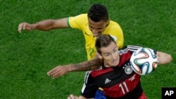 Miroslav Klose de l'Allemagne dévance Luiz Gustavo du Brésil, dans un duel aérien en juillet 2014 (AP Photo/Felipe Dana, Pool)