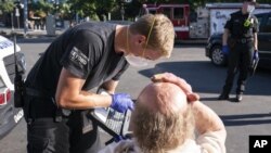 Ekipe hitne pomoći pomažu čoveku u Sejlemu, u Oregonu (Foto: AP/Nathan Howard)