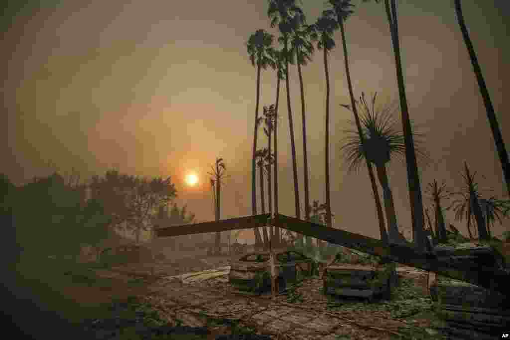 Smoke rises behind a leveled apartment complex as a wildfire burns in Ventura, Dec. 5, 2017.