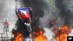 Un manifestante muestra una bandera haitiana durante una protesta para exigir la renuncia del primer ministro del país, Ariel Henry, en Puerto Príncipe, Haití, el 1 de marzo de 2024.