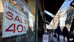 Compradores pasan frente a una tienda Indigo que ofrece descuentos hasta de 40%, en el famoso distrito comercial Magnificent Mile en Chicago, el sábado 28 de noviembre de 2020. 
