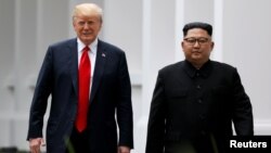 도널드 트럼프 미국 대통령과 김정은 북한 국무위원장이 지난해 6월 첫 정상회담이 열린 싱가포르 카펠라 호텔에서 나란히 걷고 있다.