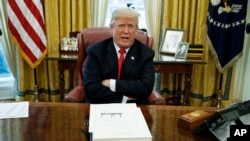 FILE - President Donald Trump speaks with reporters in the Oval Office of the White House in Washington. 