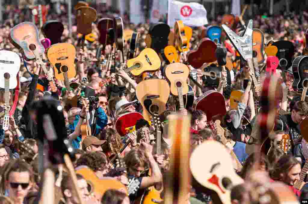 A mass gathering of guitarists attempt to beat the Guinness record for ensemble guitar playing in Wroclaw, Poland. According to media reports 7,356 musicians gathered in Wroclaw Market Square to play Jimi Hendrix's hit 'Hey Joe'.