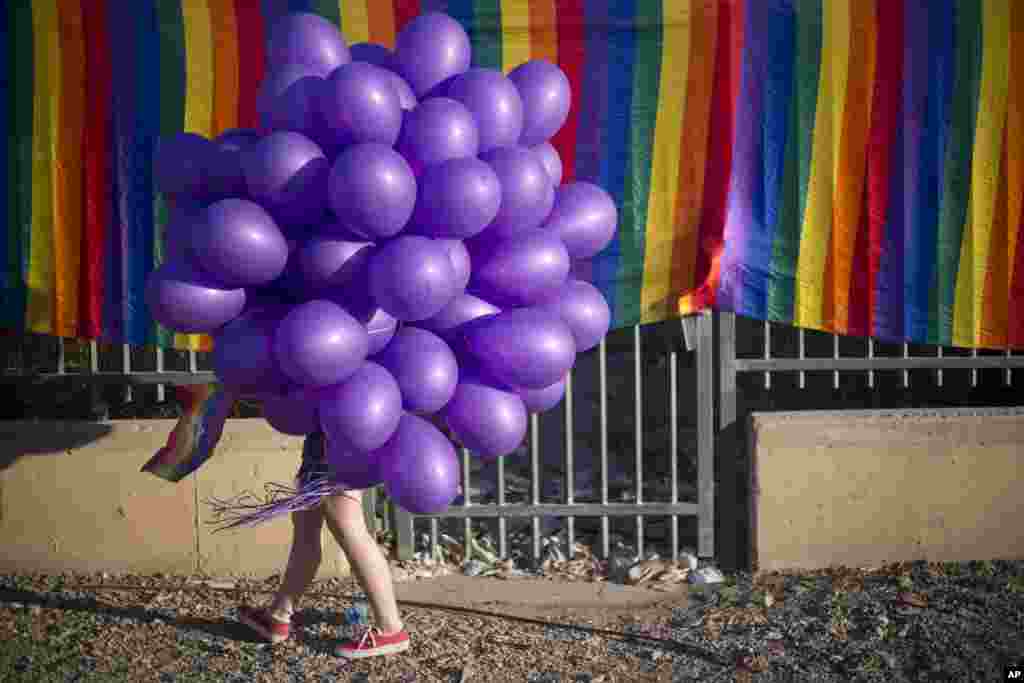 A woman holds balloons as she participates in the first Gay Pride Parade in Beersheba, Israel.