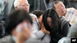 Relatives of passengers on a plane that burst into flames mourn at Muan International Airport in Muan, South Korea, Dec. 30, 2024.