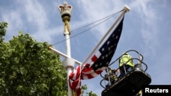 Workers hang a U.S. flag on The Mall towards Buckingham Palace in central London ahead of U.S. President Donald Trump state visit to Britain, June 2, 2019.