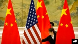 在北京钓鱼台国宾馆举行的美中贸易代表会谈前，中国工作人员正在调整美中两国国旗。(2019年2月14日)