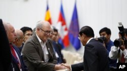 Cambodian Prime Minister Hun Sen, right, shakes hands with the international observer delegations for the July 29 general election, during a welcome meeting in Peace Palace, in Phnom Penh, Cambodia, Saturday, July 28, 2018. Cambodians voting in Sunday's elections will have a nominal choice of 20 parties but in reality, only two serious options: extend Prime Minister Hun Sen's 33 years in power or not vote at all.