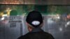 A man reads a newspaper reporting on the U.S. presidential election, at a stand in Beijing, China, Nov. 5, 2020.