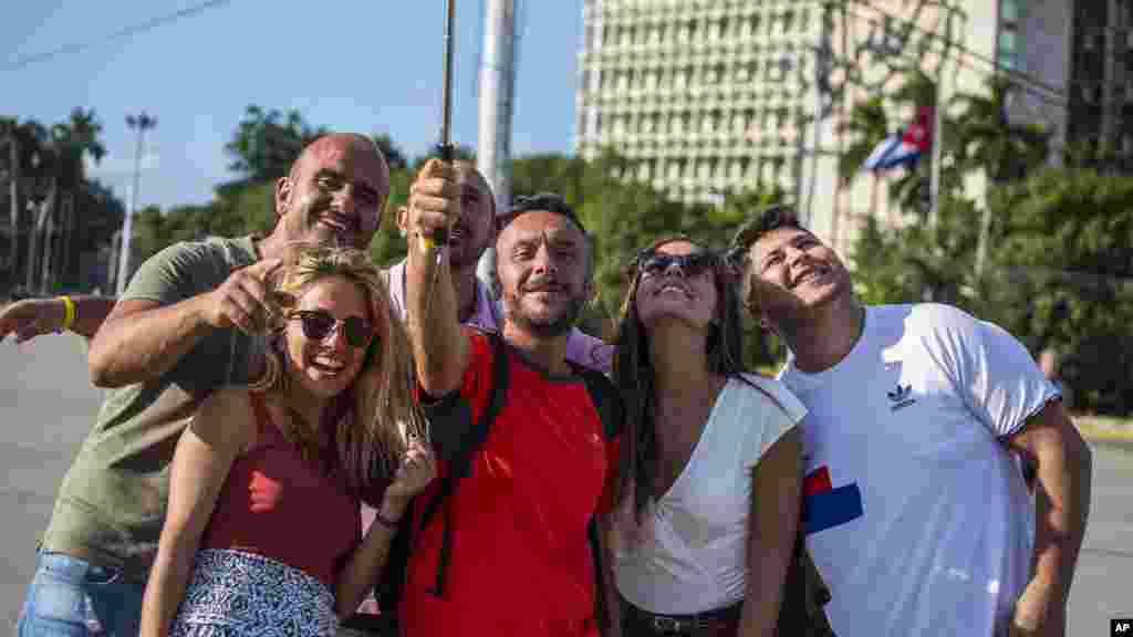 Les touristes prennent des selfies avec une image du héros révolutionnaire cubain Ernesto "Che" Guevara à la place de la révolution à La Havane, Cuba, le 27 novembre 2016.