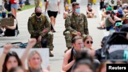 Dos capellanes de la Guardia Nacional del estado de Minnesota se arrodillan durante una protesta como muestra de apoyo a los manifestantes que claman justicia por la muerte de George Floyd, el 2 de junio.