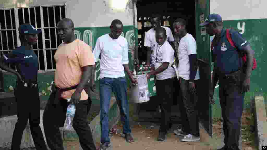 Des volontaires électoraux portent trois tonneaux servant d’urnes avant la séance de comptage des voix lors de l’élection présidentielle, à Serrekunda, Gambie, 1er décembre 2016.
