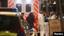 Forensic experts are seen outside a bar after a shooting in Hanau near Frankfurt, Germany, Feb. 20, 2020. 