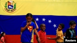 Un grupo de niños juega en las calles, frente a una bandera de Venezuela. Imagen de archivo del 7 de septiembre de 2019.