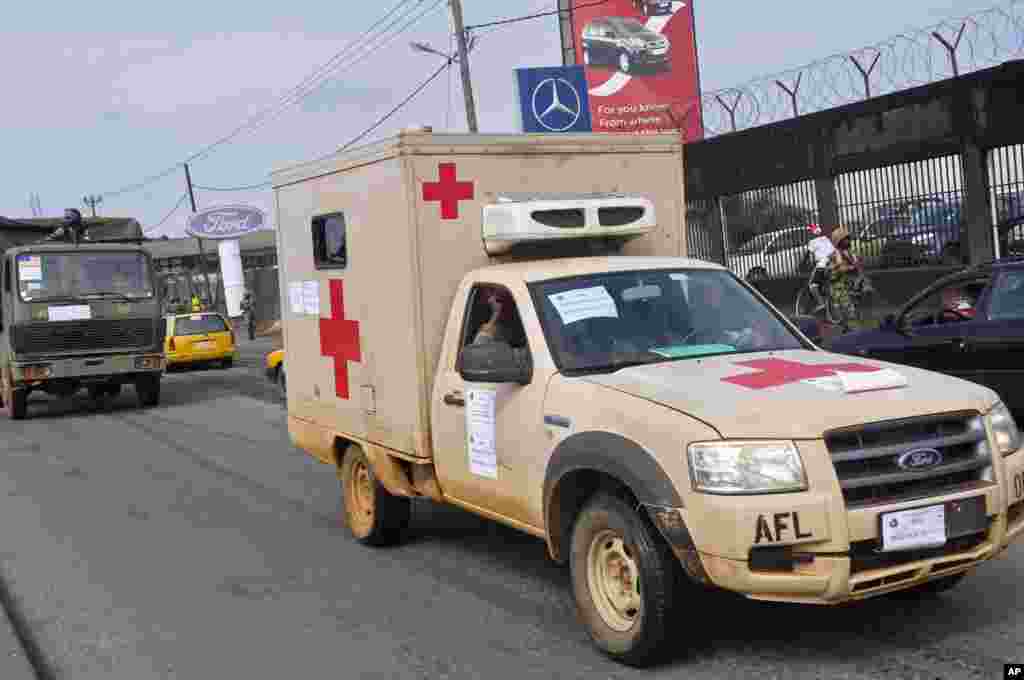 Liberian soldiers in a medical truck with a posted sign on it that reads 'Ebola Must Go,' as it drives around the city to help prevent panic, Monrovia, Liberia, August 1, 2014. 