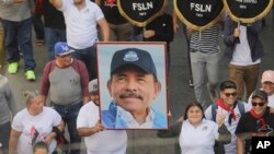 Un hombre marcha con un retrato del presidente Daniel Ortega durante una marcha progubernamental en Managua, Nicaragua, el 11 de febrero de 2023. 