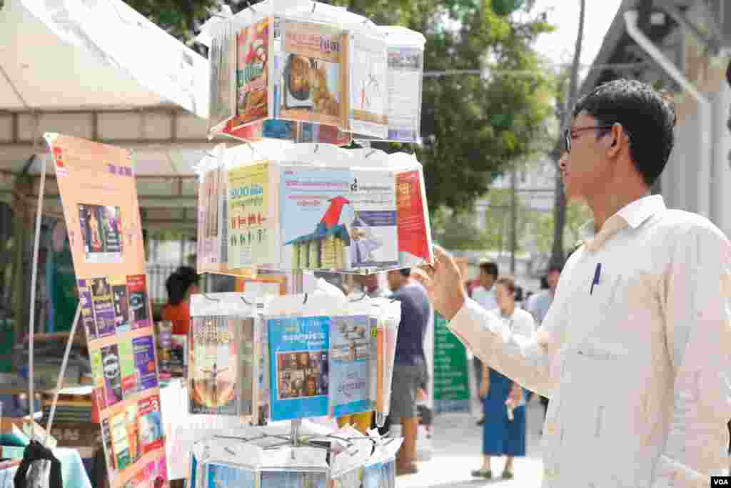 ប្រជាជនកម្ពុជា ទស្សនា និងជាវសៀវភៅ តាមស្តង់តាំងពិពណ៌និងលក់សៀវភៅ ក្នុងទិវាអំណានជាតិលើកទី២ នៅវិទ្យាស្ថានជាតិអប់រំ នាថ្ងៃទី ១១ ខែមីនា ឆ្នាំ ២០១៧។ (ខាន់ សុគុំមនោ/VOA)