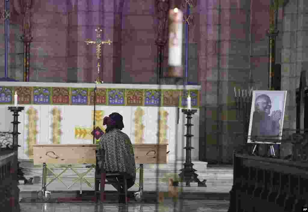 Mpho Tutu, sits with the coffin of her father Anglican Archbishop Emeritus Desmond Tutu during his funeral at the St. George's Cathedral in Cape Town, South Africa, Jan. 1, 2022.