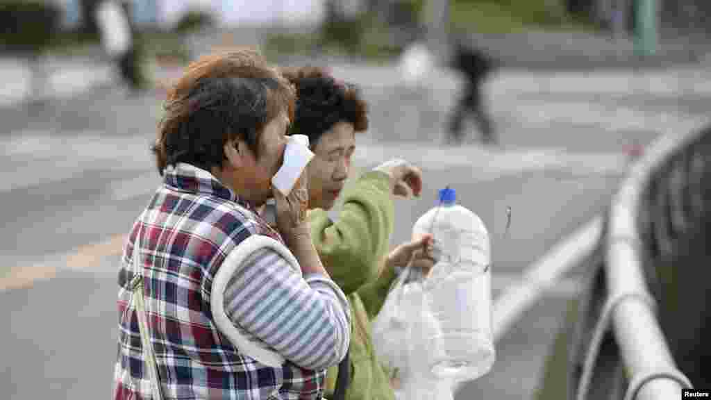 Une femme pleure après l'effondrement de sa maison à Mashiki, préfecture de Kumamoto, Japon, 17 avril 2016. Photo prise par Kyodo.