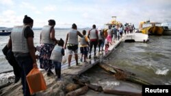 Migrantes, en su mayoría haitianos, abordan un bote en Necoclí, Colombia, con destino a Acandí, para luego cruzar a Panamá y continuar hacia el norte, el 23 de septiembre de 2021. Archivo.