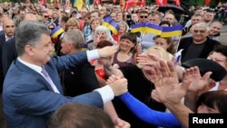Ukrainian businessman, politician and presidential candidate Petro Poroshenko (L) meets his supporters during his election rally in the city of Kryvyi Rih May 17, 2014. 