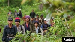FILE - Montagnard hill tribesmen walk towards the main road from dense forest 70 km (43 miles) northeast of Ban Lung, located in Cambodia's northeastern province of Ratanakiri, July 22, 2004. 