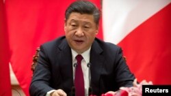 FILE - Chinese President Xi Jinping speaks during a joint press briefing at the Great Hall of the People in Beijing, China, Jan. 9, 2018.