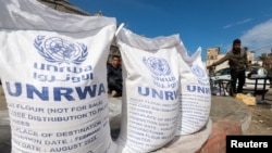 Palestinos desplazados esperan recibir ayuda de la Agencia de Obras Públicas y Socorro de las Naciones Unidas (UNRWA), en medio del conflicto en curso entre Israel y el grupo islamista palestino Hamas, en Rafah, en el sur de la Franja de Gaza, el 7 de marzo de 2024.