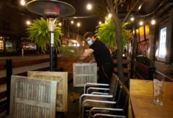 Seorang karyawan membongkar teras pemerintah Quebec memerintahkan semua restoran, bar, dan kasino tutup selama 28 hari efektif tengah malam 30 September karena jumlah COVID-19 terus meningkat di Montreal, 30 September 2020. (Foto: Reuters)