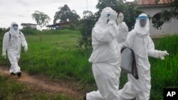 Des travailleurs de la santé cherchant à retrouver les contact du jeune homme mort du virus Ebola au Liberia (AP Photo/ Abbas Dulleh)