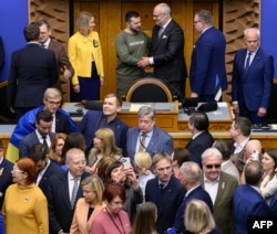 Ukrainian President Volodymyr Zelenskyy shakes hands with Estonian President Alar Karis next to Estonian Prime Minister Kaja Kallas after giving a speech to the Riigikogu, or Estonian parliament, in Tallinn on Jan. 11, 2024.