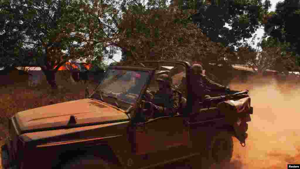 French soldiers drive past burning houses in Bossangoa, north of Bangui, Jan. 2, 2014.