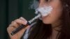 FILE - A woman smokes an electronic cigarette in London, Aug. 19, 2015.