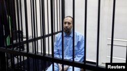 Saadi Gadhafi, anak dari mantan pemimpin Libya Moammar Gadhafi, duduk dibalik terali besi dalam sebuah persidangan di Tripoli, Libya, pada 7 Februari 2016. (Foto: REUTERS)