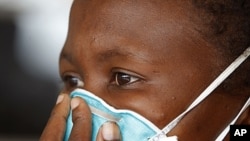 TB patient covers her face at clinic near Cape Town, South Africa, March 24, 2011 (file photo).