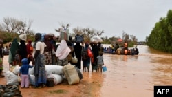 Des bateaux de la police sont utilisés pour transporter des personnes après les fortes pluies qui ont endommagé la route nationale 25 reliant Niamey aux provinces de Tillabéri et Tahoua, dans l'ouest du Niger, le 20 août 2024.