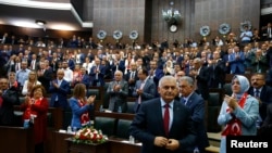 PM Turki Binali Yildrim (depan) berjalan ke mimbar untuk memberikan sambutan di hadapan parlemen di Ankara, Turki, J 19 Juli 2016 (Foto: dok). 