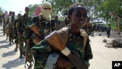 FILE - A youth leads a group of hard-line Islamist al-Shabab fighters as they conduct military exercises in northern Mogadishu's Suqaholaha neighborhood, Somalia, Jan. 1, 2010. 