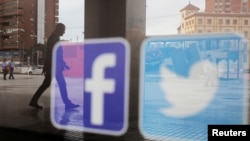 Los logotipos de Facebook y Twitter se ven en un escaparate en Málaga, España, 4 de junio de 2018.