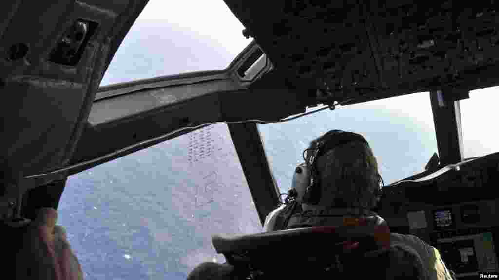 A crew member sits in the cockpit of a Royal New Zealand Air Force patrol aircraft as it continues searching in the southern Indian Ocean for Flight MH370, April 1, 2014.