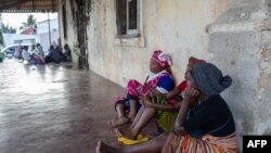 Des gens attendent aux abords du port de Pemba, le 30 mars 2021, l'arrivée éventuelle de leurs familles évacuées des côtes d'Afungi et de Palma après l'attaque des forces armées contre la ville de Palma le 24 mars 2021.
