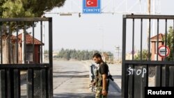 Seorang tentara Pembebasan Suriah berjaga di pintu gerbang terakhir perbatasan Suriah-Turki di Bab Al-Salam (22/5). Turki menutup perbatasan kedua negara menyusul memburuknya situasi keamanan di wilayah tersebut.