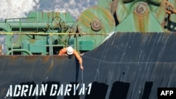 A crew member checks the new name of Iranian oil tanker Adrian Darya, formerly known as Grace 1, off the coast of Gibraltar on August 18, 2019.
