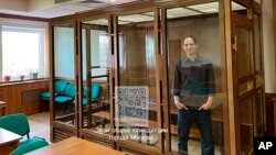 En esta fotografía, publicada por el servicio de prensa del Tribunal Municipal de Moscú, se ve al reportero del Wall Street Journal Evan Gershkovich en un ambiente de vidrio de una sala del Tribunal, el martes 26 de marzo de 2024.