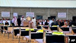 Para pelawat bersiap untuk menguburkan jenazah dari orang-orang Yazidi yang menjadi korban kejahatan yang dilakukan oleh pihak ISIS. Mereka dikebumikan di salah satu pemakaman di Sinjar, Iraq, pada 6 Februari 2021. (Foto: AP)