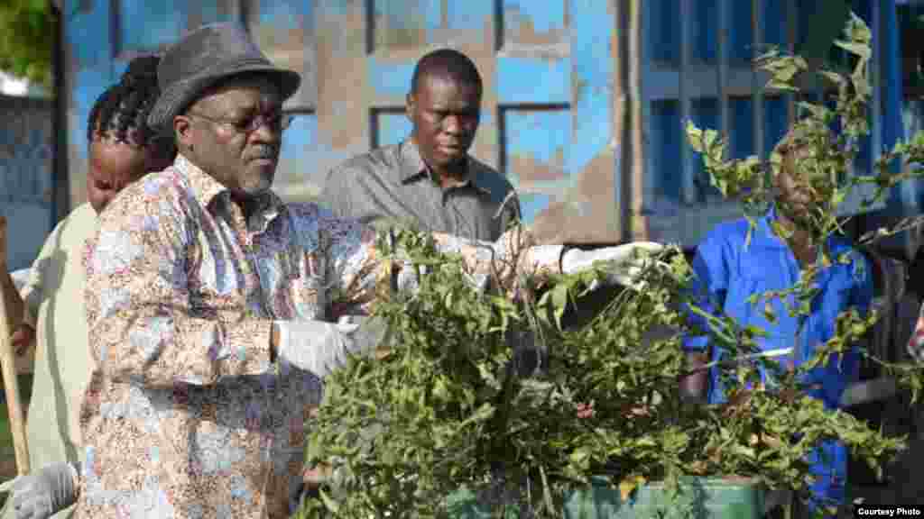 Le président tanzanien John Magufuli met des ordures dans une poubelle lors de travaux collectifs de nettoyage en commémoration du 54e anniversaire de l'indépendance du Tanganyika.