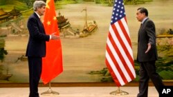 U.S. Secretary of State John Kerry, left, and Chinese Foreign Minister Wang Yi approach to shake hands after attending a news conference at the Ministry of Foreign Affairs in Beijing, Jan. 27, 2016. 